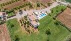 Aerial view Mediterranean finca Sa Pobla: white country house, panoramic pool, manicured lawn, 24,000 m² property