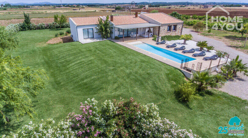 Aerial view Mediterranean finca Sa Pobla: expansive garden, panoramic pool with loungers, terrace & stone house
