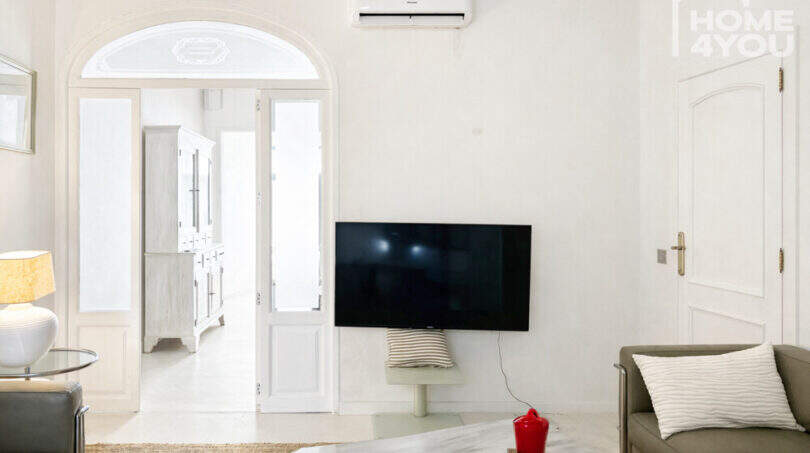 Helles Wohnzimmer mit Klimaanlage, Wandmontage-TV, Bogentür & mediterranem Stil im renovierten Stadthaus Felanitx