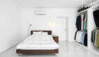 Helles Schlafzimmer mit Doppelbett, Klimaanlage und offenem Ankleidezimmer im modernen Ibiza-Stil, Felanitx