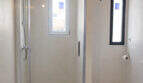 Modernes Bad mit Glasdusche, WC und kleinen Fenstern im renovierten Ibiza-Stil-Stadthaus in Felanitx.
