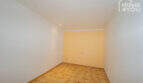 Empty room with light yellow wall accent, parquet floor and recessed lights in the multi-family house Felanitx