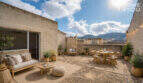 Sunny roof terrace with lounge, dining table and mountain view of the multi-family house in Felanitx