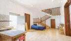 Spacious living area with wooden staircase, tiled floors and natural light in the multi-family house Felanitx