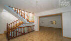 Spacious entrance area with wooden staircase and tiled floor in the multi-family house Felanitx