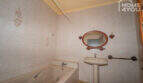 Bathroom with bathtub, sink, oval mirror and floral tile décor in the multi-family house Felanitx