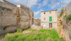 Dilapidated property in Felanitx with old stone walls, overgrown vegetation and view of neighboring buildings