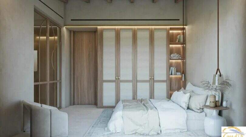 Habitación luminosa de la Finca Artà con armario empotrado de madera, techo con vigas y diseño mediterráneo