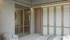 Elegante dormitorio con armarios empotrados de madera y vestidor acristalado, en la exclusiva finca de Artà