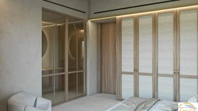 Elegante dormitorio con armarios empotrados de madera y vestidor acristalado, en la exclusiva finca de Artà