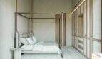Elegante dormitorio con cama con dosel, armario empotrado de madera y un toque mediterráneo en la exclusiva finca de Artà