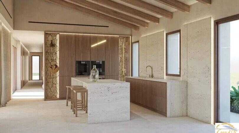 Cocina moderna de la Finca Artà con isla de mármol, techo con vigas de madera y paredes de piedra natural de estilo mediterráneo