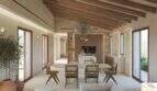 Salón-comedor diáfano con techo de vigas de madera, isla de cocina y sillas de ratán en una finca exclusiva, Artà
