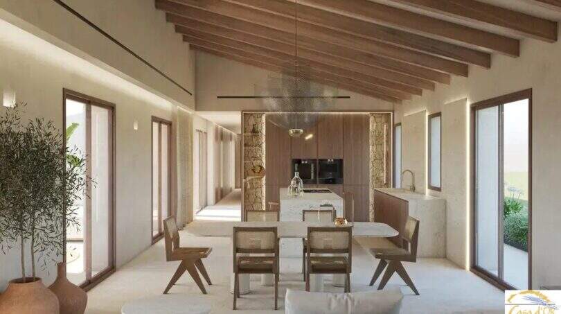 Salón-comedor diáfano con techo de vigas de madera, isla de cocina y sillas de ratán en una finca exclusiva, Artà