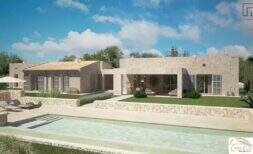 Exterior view of an exclusive finca in Artà with a pool, natural stone walls, and Mediterranean charm