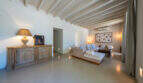 Helles Wohnzimmer der Finca in Esporles mit Holzbalkendecke, elegantem Sofa und rustikalem Sideboard.