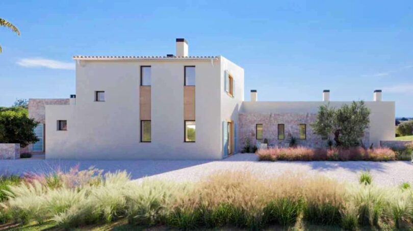Außenansicht einer modernen Finca in Cala Murada, Manacor, mit weißer Fassade, Naturstein und mediterraner Bepflanzung.