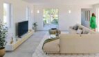Helles Wohnzimmer der Finca in Cala Murada mit Sofa, TV-Möbel und Terrassentür zum Garten
