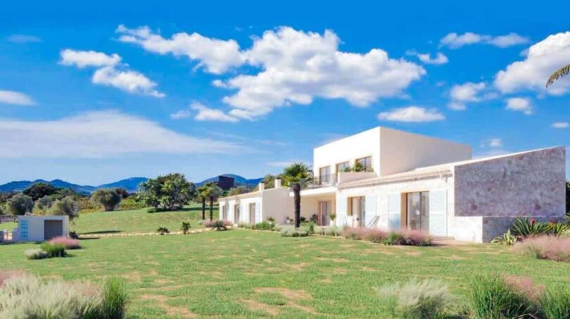 Moderne Finca in Cala Murada mit weitläufigem Grüngarten, Natursteinfront und Blick auf Hügel