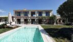 Luxusfinca Ses Salines: Außenpool mit Sonnenliegen, zweigeschossige Villa mit Fensterläden und Pergola