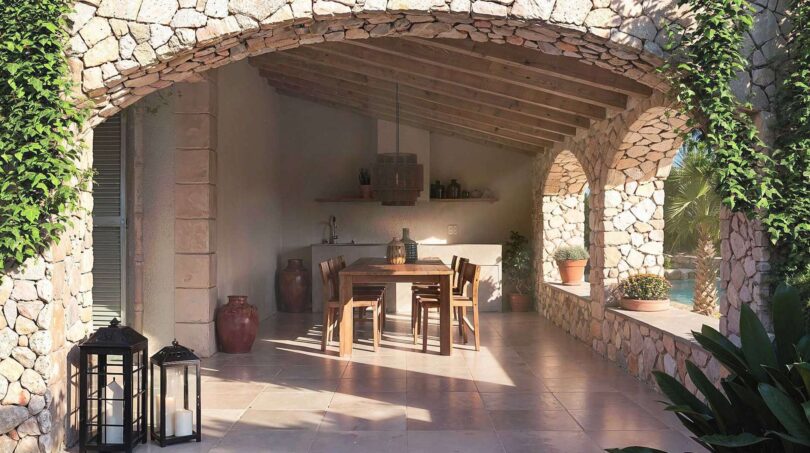 Überdachte Außenterrasse mit Natursteinbogen, Holzdecke und Esstisch der Luxusfinca in Ses Salines