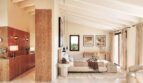 Helles Schlafzimmer der Luxusfinca mit Holzakzenten, Dachbalken und großzügigem Bett in Ses Salines.
