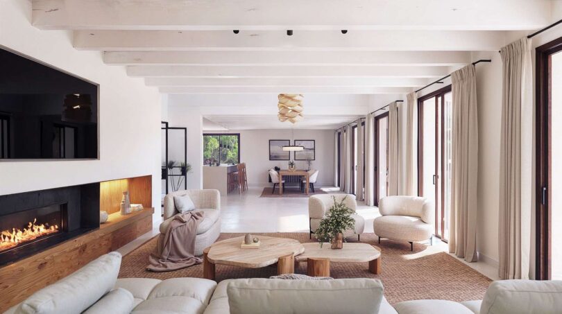 Helles Wohnzimmer der Luxusfinca in Ses Salines mit Kamin, Exposed Beams und offenem Grundriss