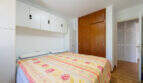 Schlafzimmer mit Doppelbett, Einbauschränken und Holzparkett im Erdgeschossapartment Cala Murada