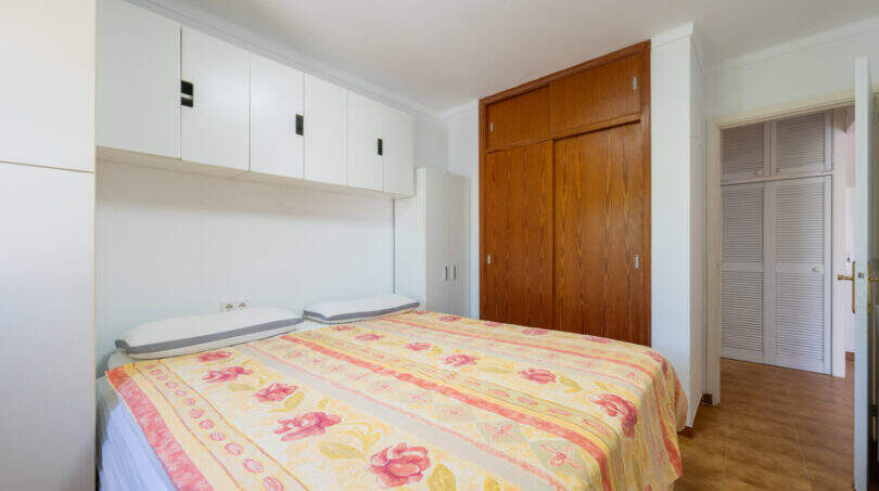 Schlafzimmer mit Doppelbett, Einbauschränken und Holzparkett im Erdgeschossapartment Cala Murada