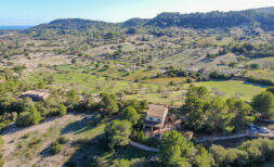 Aerial view of Finca Son Macià, nestled among green hills with ocean views and a spacious property.