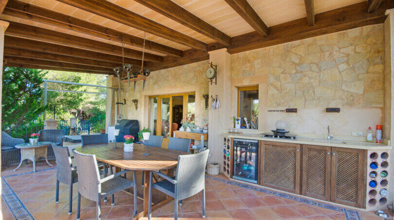 Überdachte Außenterrasse der Finca mit Outdoor-Küche, Holzbalkendecke und Essbereich für mehrere Personen.
