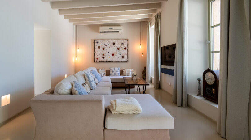 Helles Wohnzimmer der Finca in Esporles mit Ecksofa, Holzbalkendecke und mediterranem Flair.