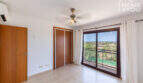 Helles Schlafzimmer mit Einbauschrank, Deckenventilator, Klimaanlage und Balkon mit Grünblick