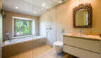 Modernes Badezimmer der Finca in Esporles mit Glasdusche, Einbaubadewanne und orientalischem Spiegel.