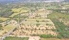 Fotografía aérea de terreno urbanizable en Felanitx con paisaje extenso, campos y calle, vista hacia la ciudad
