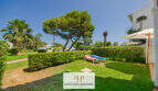 Gepflegter Gemeinschaftsgarten mit Liegestühlen, Palmen und Pinien der Apartmentanlage in Cala d'Or