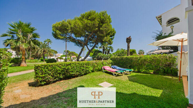 Gepflegter Gemeinschaftsgarten mit Liegestühlen, Palmen und Pinien der Apartmentanlage in Cala d'Or