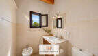 Helles Badezimmer der Finca Felanitx mit Bidet, Waschtisch, Spiegel und Holzbalkendecke