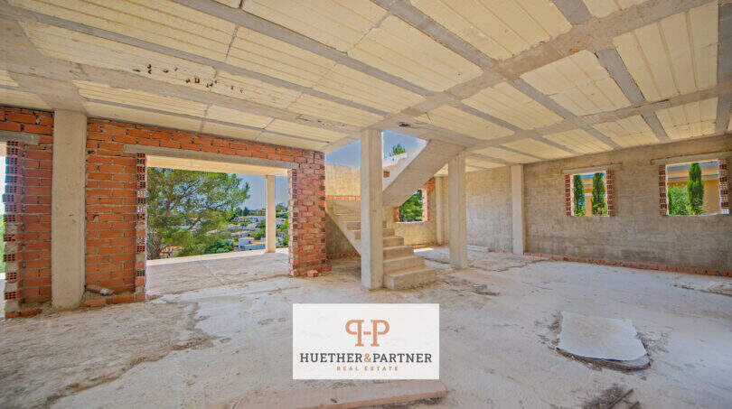 Rohbau-Innenbereich mit Betondecke, Treppe und Ausblick ins Grüne in Cala Romántica