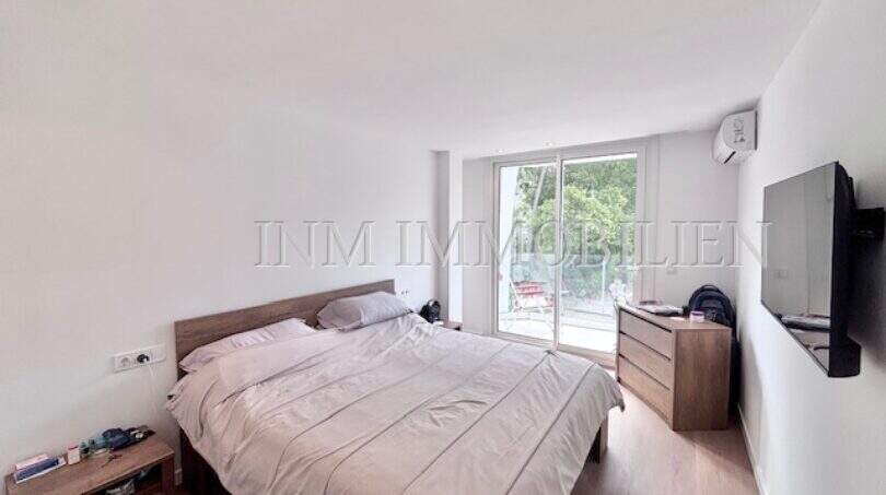 Helles Schlafzimmer mit Doppelbett, Holzmöbeln, TV und Balkonzugang in Apartment Palmanova
