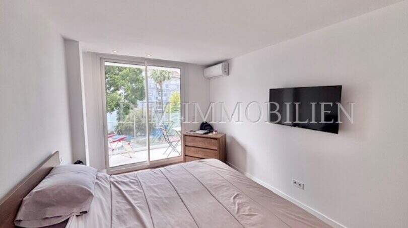 Helles Schlafzimmer mit Doppelbett, Wandmontiertem TV, Klimaanlage und Zugang zur Terrasse in Palmanova
