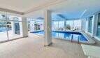 Überdachter Innenpool mit großen Fensterfronten und Meerblick im Apartment-Komplex in Palmanova