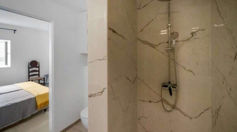 Moderno baño en suite con ducha de mármol y vista al dormitorio en la casa de ciudad Felanitx