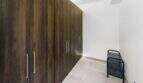 Espacioso vestidor con armarios empotrados de suelo a techo en madera oscura en la casa de ciudad Felanitx