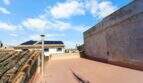 Terraza plana en la azotea con vista a edificios vecinos con instalación solar y tejados de barro tradicionales en Felanitx