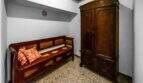 Zona de entrada con armario antiguo de madera y banco rústico, encanto típicamente mallorquín en la casa de ciudad Felanitx