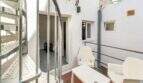 Terraza con sillas de plástico blanco, escaleras metálicas y acceso a la casa de ciudad en Felanitx