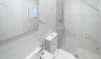 Moderno baño con azulejos de mármol, ducha, inodoro y lavamanos en la casa de ciudad Felanitx
