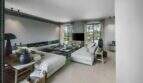 Helles Wohnzimmer der Finca bei Portocolom mit weißen Sofas, Flachbild-TV und Blick auf Palmen