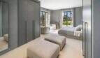 Elegantes Schlafzimmer der Finca Portocolom mit Einbauschränken, Doppelbett und Gartenblick durch französische Türen